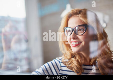 Charming female writing on transparent board in office Stock Photo