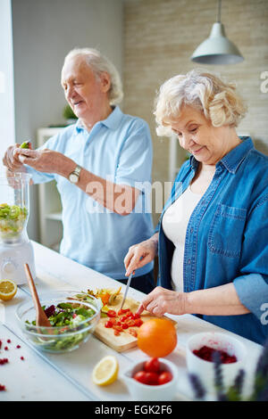 Senior husband and wife cooking together Stock Photo