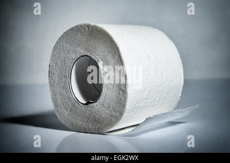 Toilet paper roll  toned blue laying on table Stock Photo