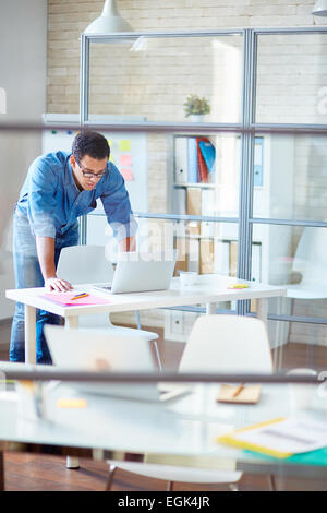 Businessman in denim clothes using laptop in office Stock Photo
