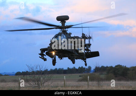 British Army Apache AH1 attack helicopter prepares to land at dusk during a training exercise in Wiltshire. Stock Photo