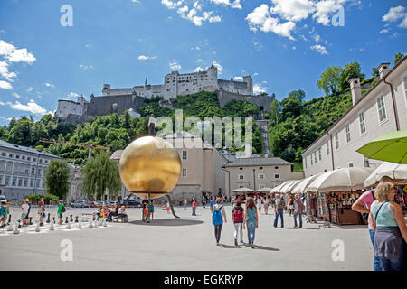 Kapitelplatz square, yellow ball sculpture and Salzburg Castle Salzburg Austria Stock Photo