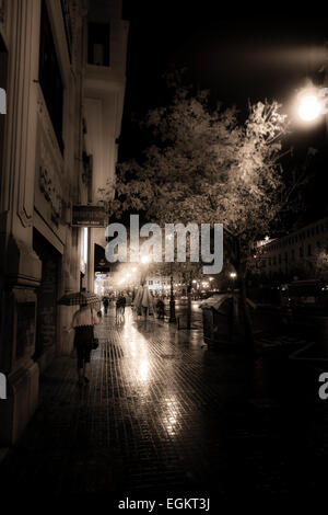 Wet and rainy city streets of Valencia at night with street lights and reflections Stock Photo