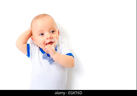 Smiling baby boy lying on white floor Stock Photo