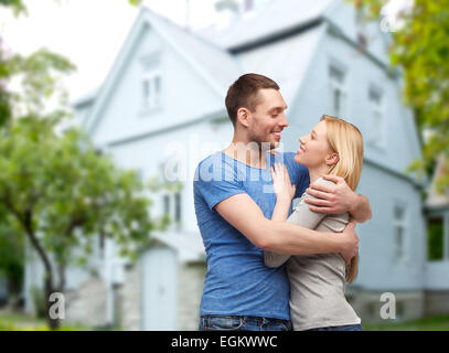 smiling couple hugging over house background Stock Photo