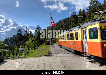 Train leaving station at Grutschalpin in the Jungfrau Region of the Bernese Oberland of Switzerland headed to Murren. Stock Photo