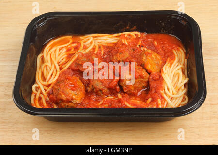 Spaghetti and meatballs in a plastic carton on a wooden board Stock Photo