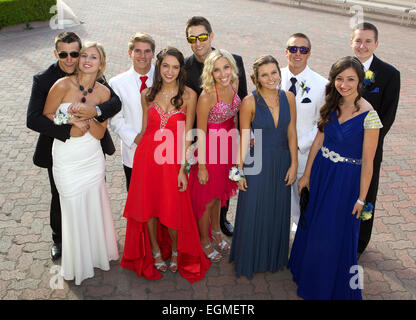 A happy group of high school students posing for a prom photo in their prom dresses and tuxedos Stock Photo