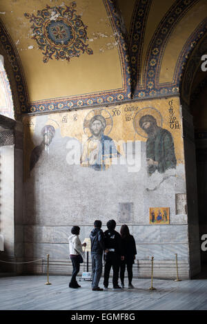 ISTANBUL, Turkey — The renowned Deësis mosaic in Hagia Sophia's upper gallery dates to approximately 1261. This Byzantine masterpiece depicts Christ Pantocrator flanked by the Virgin Mary and John the Baptist in three-quarter profile, illustrating their intercession for humanity. The mosaic represents one of the finest surviving examples of Byzantine religious art. Stock Photo