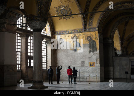 ISTANBUL, Turkey — The renowned Deësis mosaic in Hagia Sophia's upper gallery dates to approximately 1261. This Byzantine masterpiece depicts Christ Pantocrator flanked by the Virgin Mary and John the Baptist in three-quarter profile, illustrating their intercession for humanity. The mosaic represents one of the finest surviving examples of Byzantine religious art. Stock Photo