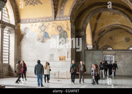 ISTANBUL, Turkey — The renowned Deësis mosaic in Hagia Sophia's upper gallery dates to approximately 1261. This Byzantine masterpiece depicts Christ Pantocrator flanked by the Virgin Mary and John the Baptist in three-quarter profile, illustrating their intercession for humanity. The mosaic represents one of the finest surviving examples of Byzantine religious art. Stock Photo