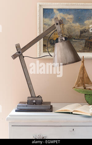 Vintage metal table lamp on chest of drawers Stock Photo
