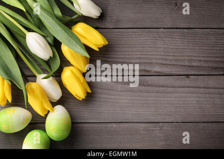 Tulips and easter eggs on wood background Stock Photo