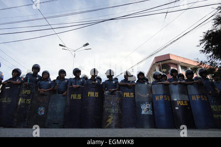 Manila, Philippines. 27th February, 2015. Philippine policemen gather outside the gates of Mendiola Peace Arch during a rally near Malacanang Palace. The protesters are calling for the resignation of President Benigno Aquino III over the Mamasapano incident that resulted in the deaths of wanted Malaysian bombmaker Zulkifri 'Marwan' bin Hir, 44 police commandos, 18 Muslim rebels, and 8 civilians. Credit:  Richard James Mendoza/Pacific Press/Alamy Live News Stock Photo