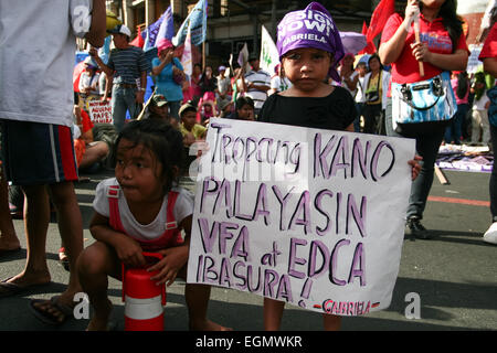 Manila, Philippines. 27th February, 2015. A young girl holding a poster calling for the removal of American military forces in the country during the march to Mendiola, Manila. Composed mostly of students, they walked out of their class to air their resentment over Aquino's alleged inefficiency in governing and solving the country's problems. Militant groups also joined the march to the call for Aquino's resignation. Credit:  J Gerard Seguia/Pacific Press/Alamy Live News Stock Photo