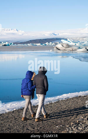 Tourists walking in snow covered trail in canyon, Johnston Canyon ...