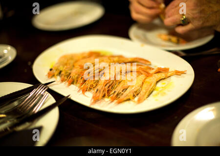 unpeeled prawns on a restaurant table in oil Stock Photo