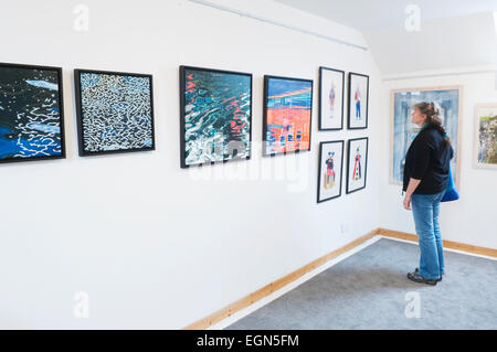 Woman looking at an exhibition in the Loft Gallery, St Margaret's Hope, South Ronaldsay, Orkney Islands, Scotland.