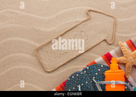 Mexico pointer and beach accessories lying on the sand, as background Stock Photo