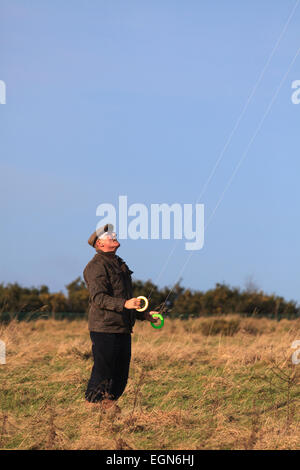 Older man flying stunt kite using dual control lines Stock Photo