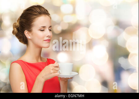 smiling woman in red dress with cup of coffee Stock Photo