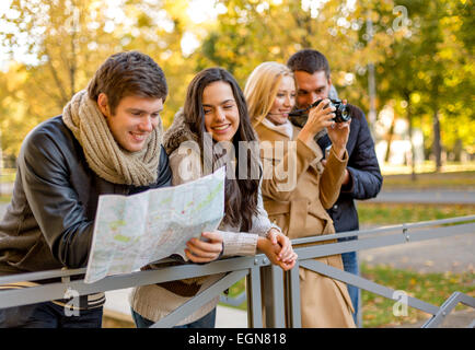 group of friends with map and camera outdoors Stock Photo