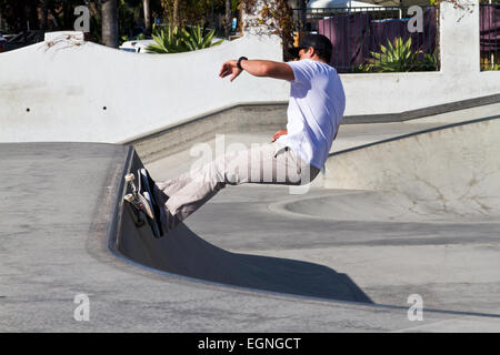 A young man performing a stunt on a skateboard at a skate park in Santa Barbara, California. Stock Photo