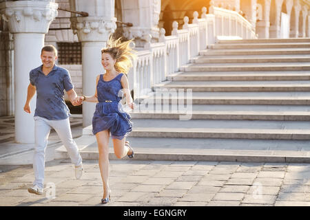 happy couple holding hands smiling and running in Venice, Italy Stock Photo
