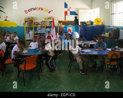 Primary school children in class Puerto Plata Dominican Republic concentrating on their lessons despite a visit from a group of tourists Stock Photo