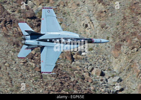 Close Up Topside View Of A US Navy F/A-18F Super Hornet Jet Fighter Maneuvering Close To The Desert Terrain. Stock Photo