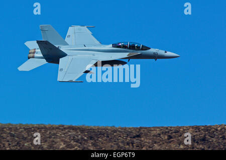 Close Up Topside View Of A US Navy F/A-18F Super Hornet Jet Fighter Flying Along The Rim Of A Desert Canyon. Stock Photo