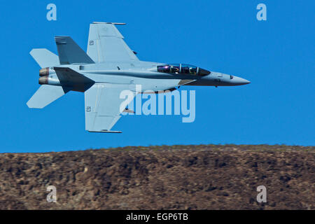 Close Up Topside View Of A US Navy F/A-18F Super Hornet Jet Fighter Flying Along The Rim Of Rainbow Canyon, California. Stock Photo