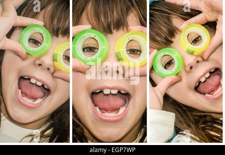 Beautiful little girl is looking through the circles of a scotch tape pretending to have binoculars on Stock Photo