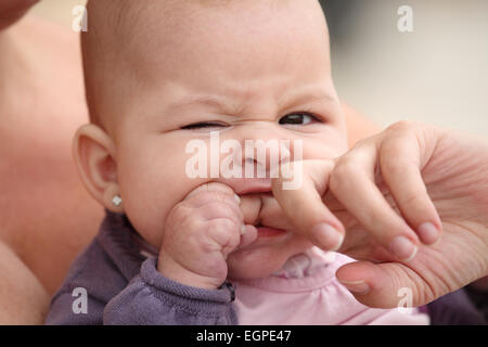 little baby biting her mother finger Stock Photo