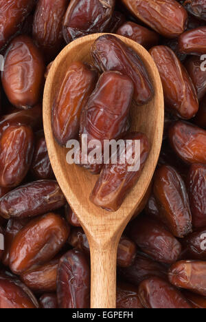 Wooden spoon with dried dates lies on the dates Stock Photo