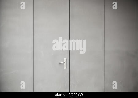 Gray metal door, detail of a closed metal door painted gray steel background texture Stock Photo