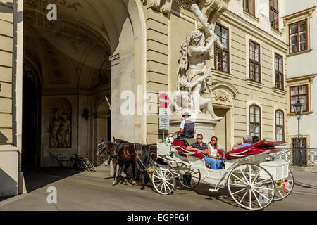 Horse carriage with tourists riding through a passage in Hofburg Palace, Vienna, Austria Stock Photo