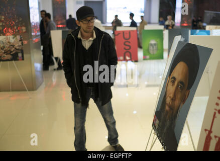 Tehran, Iran. 28th Feb, 2015. An Iranian man looks on a poster with a photoshopped portrait of the U.S. President BARACK OBAMA while visiting of the Second Major International Award of Down with America's Exhibition in Tehran's War (In Iran known as Holy defense) Museum. Credit:  Morteza Nikoubazl/ZUMA Wire/Alamy Live News Stock Photo