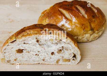 Fresh whole grain bread cut in half on cutting board Stock Photo
