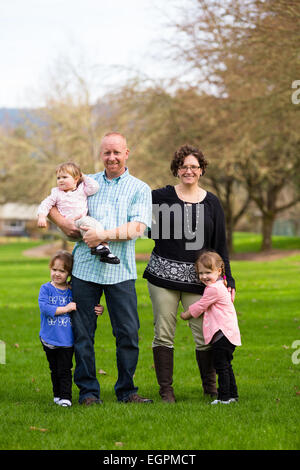 Lifestyle photo of a family of five including mother, father, and three daughters. Two daughters are identical twins. Stock Photo