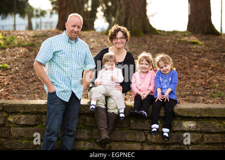 Lifestyle photo of a family of five including mother, father, and three daughters. Two daughters are identical twins. Stock Photo