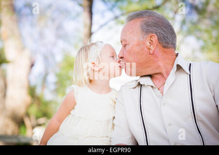 Loving Grandfather and Granddaughter Kissing Outside At The Park. Stock Photo