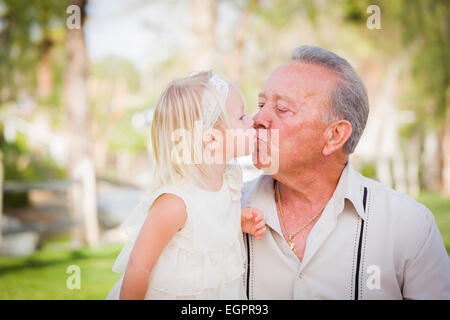 Loving Grandfather and Granddaughter Kissing Outside At The Park. Stock Photo