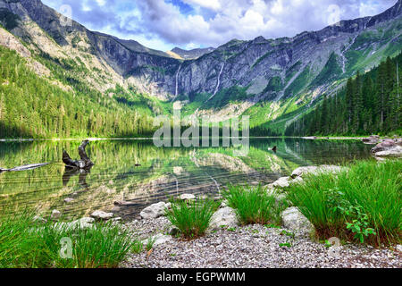 gorgeous sunlit Avalanche lake with reflection in Glacier National Park Stock Photo