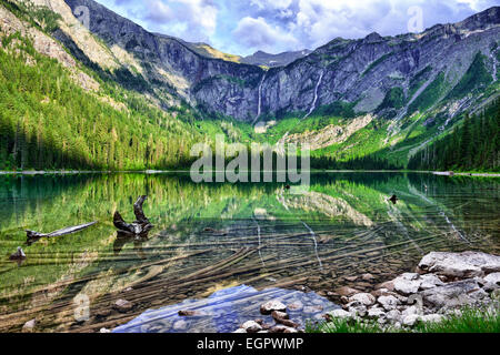 gorgeous sunlit Avalanche lake with reflection in Glacier National Park Stock Photo