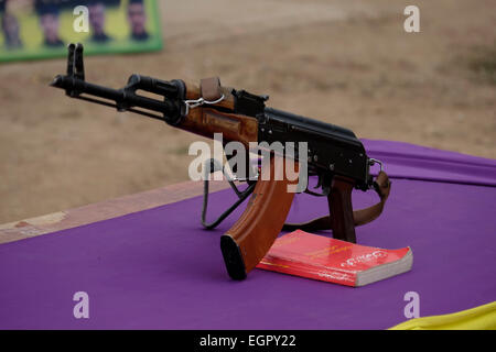 A Kalashnikov ak-47 rifle placed on a table with the Political Thought of Abdullah Ocalan Kurdish leader and one of the founding members of the militant Kurdistan Workers' Party PKK during swearing ceremony of Kurdish fighters YPG in a recruitment camp in Al Hasakah or Hassakeh district in northern Syria