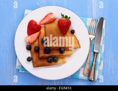 Stack of pancakes, fresh strawberry blueberry, cutlery, top view Stock Photo