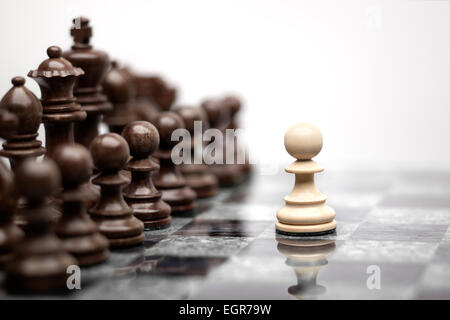 One pawn staying against full set of chess pieces. Stock Photo