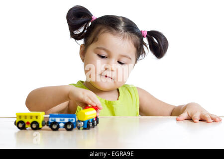 Cute kid girl playing trains Stock Photo