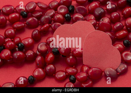 heart, coral necklace on a red background Stock Photo
